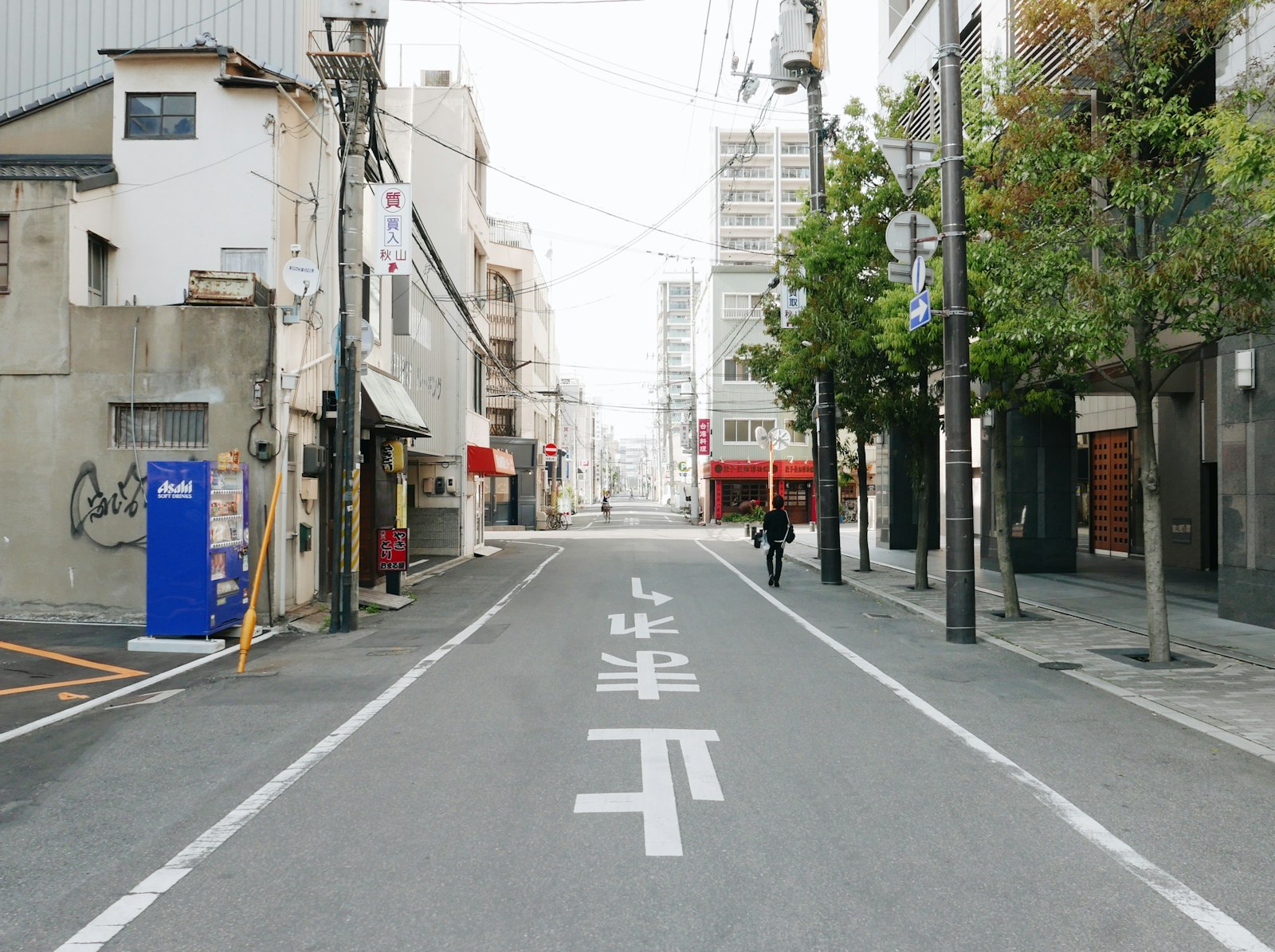 朝の境内を掃く人